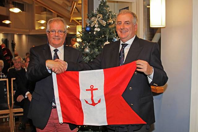 HYC outgoing Commodore Berchmans Gannon (left) presents the office holder’s burgee to incoming Commodore Joe McPeake