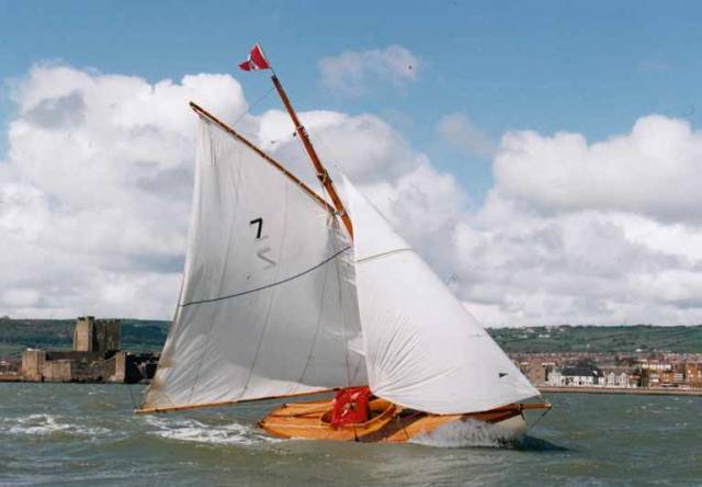 Centenary Season. Twenty years ago in April 1998, Ian Malcolm’s Howth 17 Aura celebrates her Centenary by returning to her birthplace of Carrickfergus on Belfast Lough with its famous 12th Century Norman castle