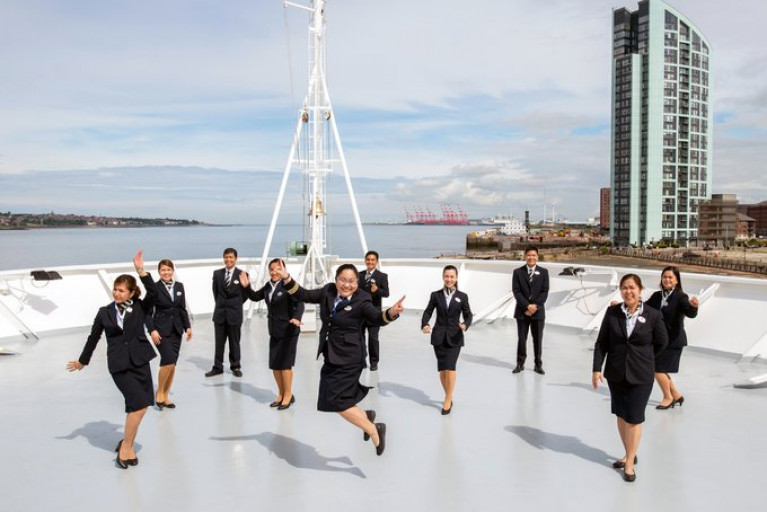 Resumption of UK cruises continue as Fred Olsen Guest Services team seen jumping for joy as they get ready to welcome their first guests on board Borealis Maiden Voyage Cruise which started last night.  The inaugural 3 nights cruise of the Scottish Western Isles, embarked guests at the Irish Sea port of Liverpool from where the cruiseship set off to tour scenic sights among them the Isle of Staffa. 