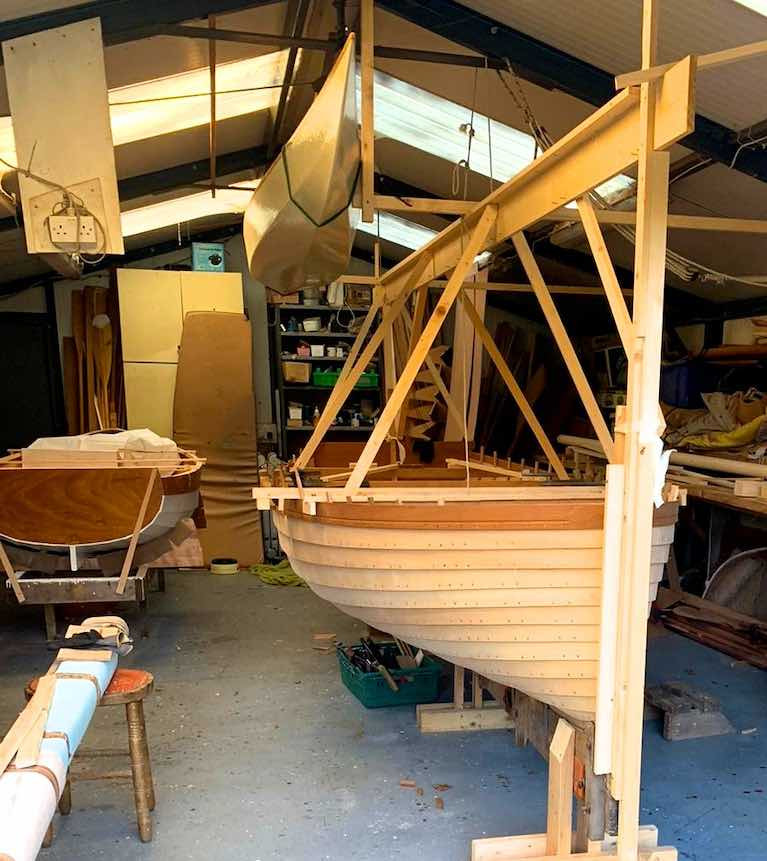 Better than a Health Farm……the soothing setup in the McMahon shed in Athlone, with the &quot;new-old&quot; Dublin Bay Water Wag Shindilla (original built in 1932) nearing completion beside a useful little clinker-built dinghy, while a multi-purpose canoe with sailing potential is stored by suspension from the roof