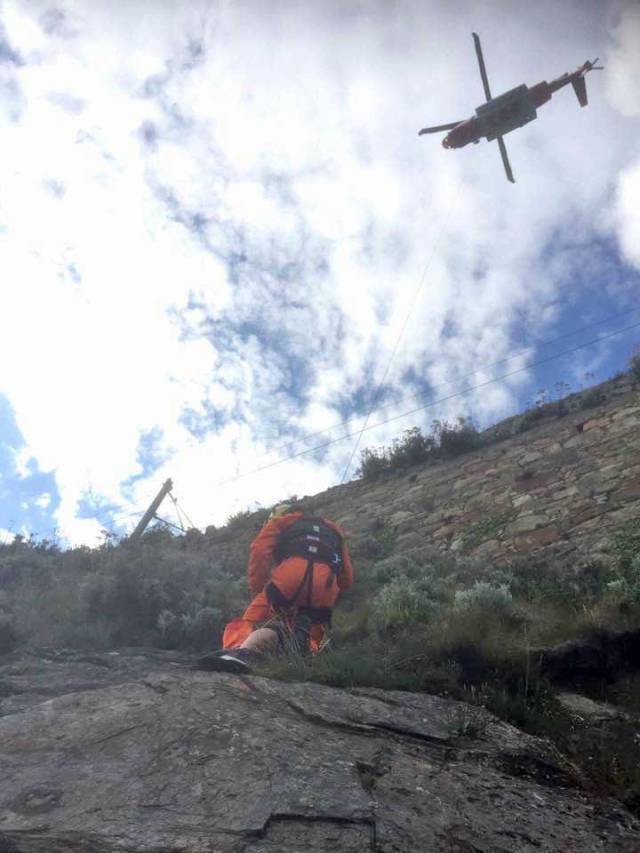 Rescue 116’s winch man prepares to lower the stranded woman from the cliff face at Whiterock