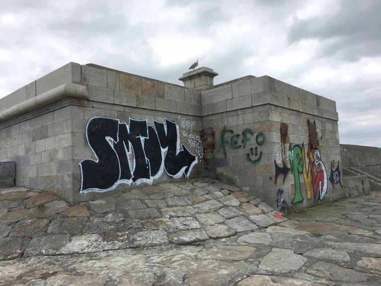 Vacant buildings are blighted by graffitii on Dun Laoghaire's West Pier. The council says graffiti poses a significant problem throughout the Dun Laoghaire area