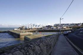 Local anger over decision to allow Bartra Capital build luxury villas and apartments at the coastal inlet at Bulloch Harbour, Dalkey in Co. Dublin and above an illustration of the proposed development.