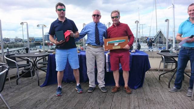Ross Nolan (left) and Gordon Patterson (right) receive their Championship prize from Howth Yacht Club Commodore Ian Byrne