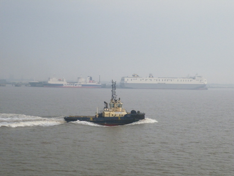 Brexit 'Freeports': Logistics UK welcomes the move to offer ‘an ambitious customs model, measures to speed up planning processes, and a commitment to geographic flexibility and opportunities for all transport modes’. Above AFLOAT's photo of a hazy Humber Estuary (Killingholme) on the North Sea. On the right Delphine which in 2018 joined sister Celine dubbed the 'Brexit-Buster' on Ireland-mainland Europe services of Dublin-Belgium/Netherlands. On the left another ro-ro freight-ferry Stena Scotia currently operates on the Irish Sea between Belfast and Heysham, England. In the foreground heading upriver the 70 bollard pull tonnes tug Svitzer Laura.