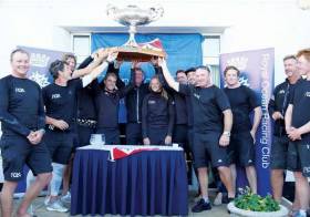 Justin Slattery (fourth from right) lifts the One Ton Cup in Cowes