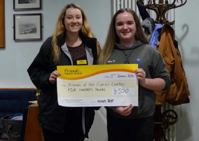 CAYC junior vice captain Hannah Todd presenting Amy from Friends of the Cancer Centre with a cheque for £500