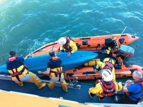 RNLI volunteers assist one of the three kayakers who attempted to aid the rescue of an injured teenager in Courtown Harbour, as featured on BBC Two’s Saving Lives at Sea this Thursday 23 August