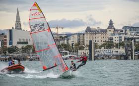 A 29er junior skiff dinghy flies past the Royal St. George Yacht Club during try–out sessions in Dun Laoghaire Harbour