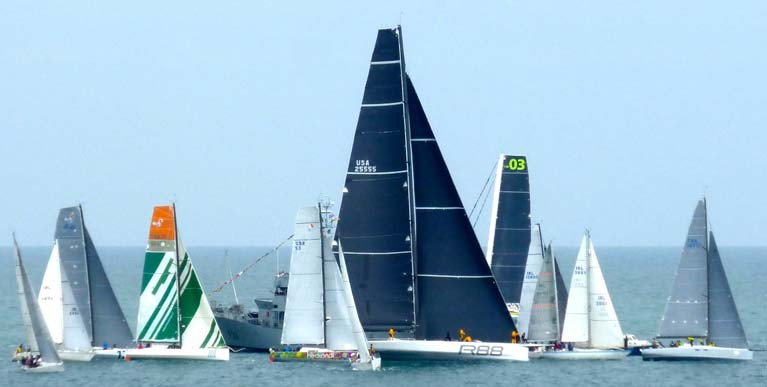 George David’s mighty Rambler 88 somehow finds a way through a motley yet representative group at the Naval vessel at the start of the Round Ireland 2016. Included are Class 40s, the J/109 and class winner Euro Carparks (on port), multiple winner Cavatina and Eric de Turkheim’ Teasing Machine from France, while beyond is an MOD 70 waiting for the Multi-hull start