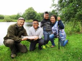Oisin Cahill of the Dublin Angling Initiative with Darcy Davila Santos (10), his brother Darren (8) and their mother Doreen at Annamoe Fisheries in Co Wicklow last summer. Darcy, a pupil of Rathdrum National School, landed a 4lb rainbow trout to win the Sean McMorrow Memorial Trophy