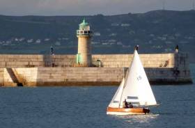Making history. David &amp; Sally MacFarlane sailing the 107-year-old Moosmie on their way to winning the first Water Wag race with a fleet of more than thirty boats, with Dun Laoghaire Harbour’s wonderful stonework looking its classic best