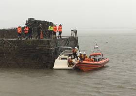 Youghal’s lifeboat volunteers tie the pleasure craft to the pier head in the harbour