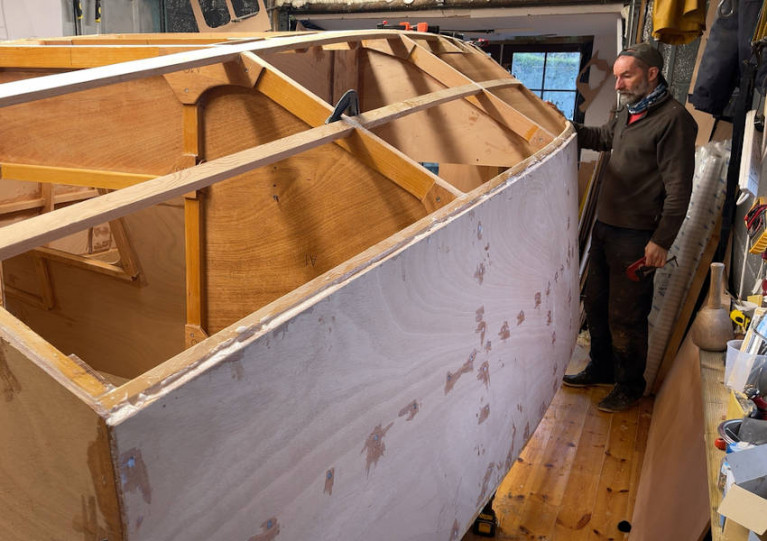 Jim Schofield with the plywood-and-epoxy hull of his ClassGlobe 5.80