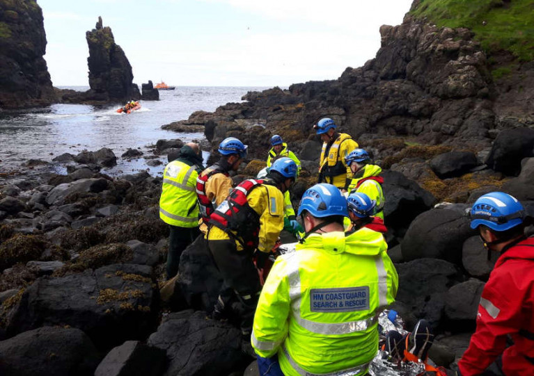 Coastguard and lifeboat volunteers stretcher the casualty from the cave in Smuggler’s Cove on Friday 7 August