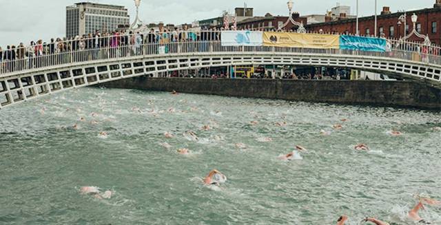 Spectators on the Ha’penny Bridge cheer on previous Liffey swimmers