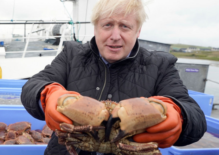UK Prime Minister Boris Johnson comes to grips with live crab in Orkney this past July