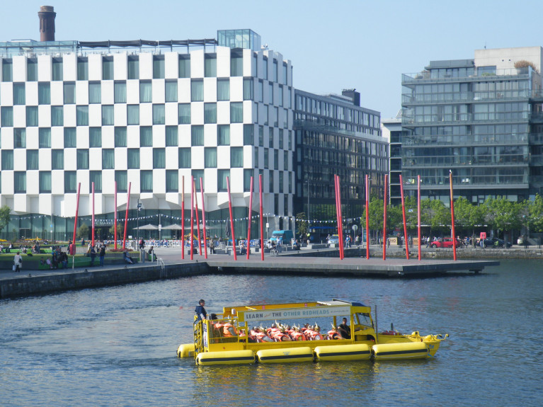 A Viking Splash tour amphibious vehicle &#039;Duk&#039; sails around Dublin’s Grand Canal Dock (as above in Afloat &#039;s photo) with the backdrop of the &#039;Docklands&#039; quarter. 